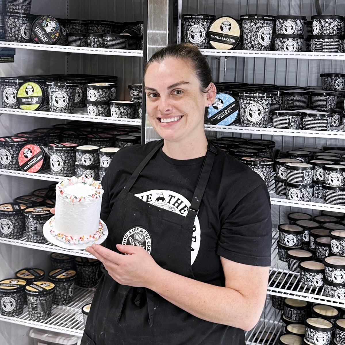 owner of ice cream shop holding a small ice cream cake