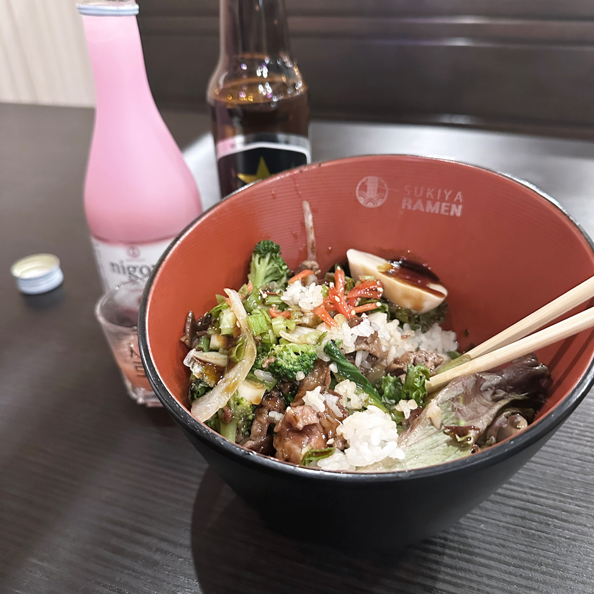 bowl opf ramen noodles with sake bottle in background