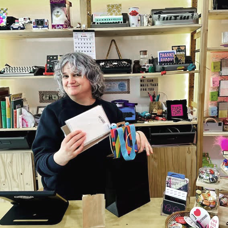 person holding a framed best of denver magazine cover - text says winner for best store for paper snobs